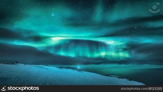 Aurora borealis over ocean. Northern lights and frozen sea coast. Starry sky with polar lights and clouds. Night winter landscape with aurora, sea with blurred water, snowy mountains. Travel