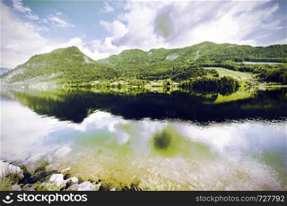 Austrian landscape with forests, meadows, fields and pastures surrounding the lake Grunlsee on the background of Alps. Vintage style