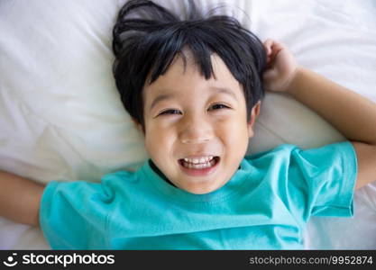 Authentic close up of happy kid in a bed. Concept of new generation, family, parenthood, authenticity, Son
