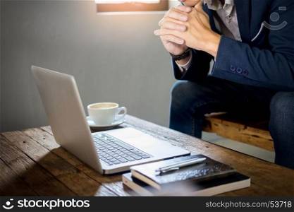 Authentic image of a pensive businessman in a coffee shop sitting in cafe and working.