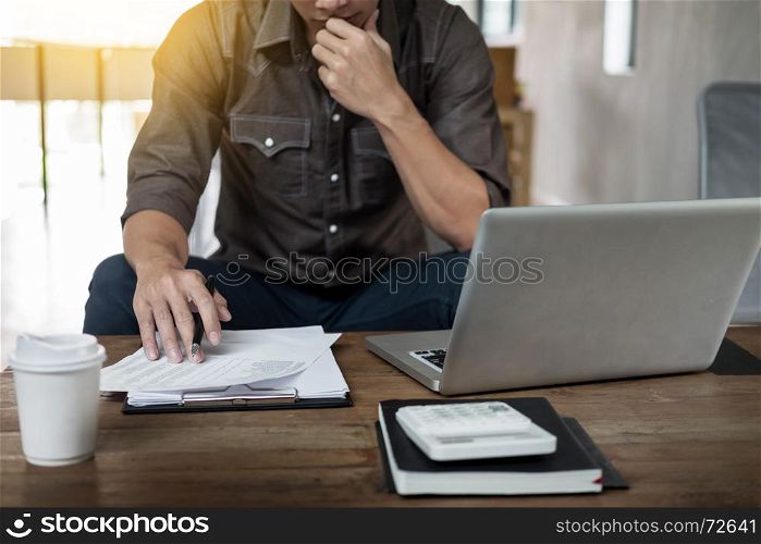 Authentic image of a pensive businessman in a coffee shop sitting in cafe and working.