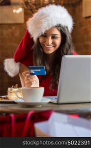 Authentic image of a young woman paying her bill in a cafe wearing christmas hat