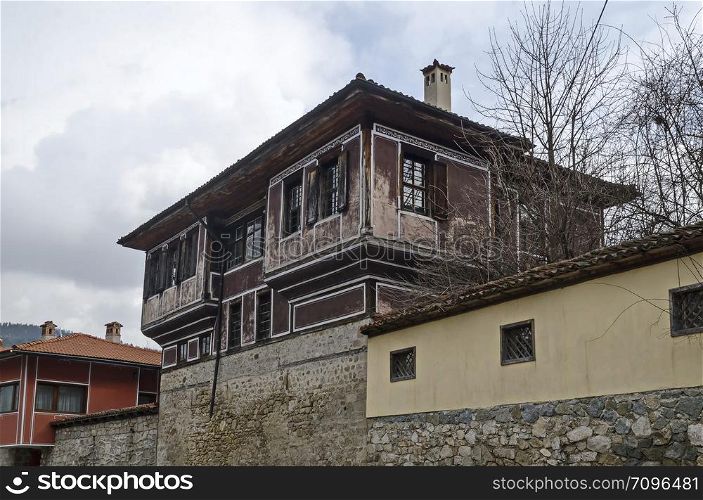 Authentic unique residential district with painted in bright colors houses, stone walls, wooden windows, verandahs and picturesque eaves, Koprivshtitsa town, Bulgaria, Europe