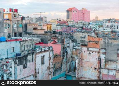 Authentic view of a street of Old Havana with old buildings and cars. HAVANA, CUBA - APRIL 14, 2017  Authentic view of a abandoned house and street of Old Havana