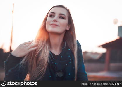 Authentic woman portrait on the street in mild sunset light, enjoying city life, outdoors photoshoot, autumn urban fashion