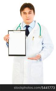 Authoritative medical doctor pointing at blank clipboard isolated on white&#xA;