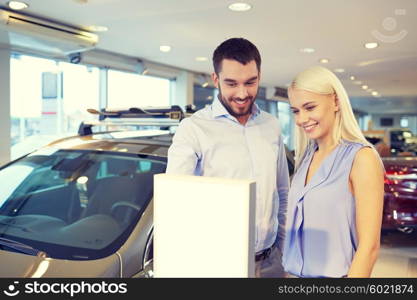 auto business, car sale, consumerism and people concept - happy couple buying car in auto show or salon