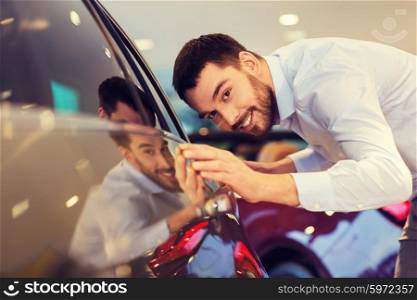 auto business, car sale, consumerism and people concept - happy man touching car in auto show or salon