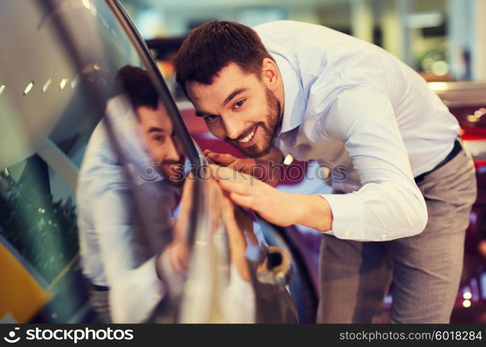 auto business, car sale, consumerism and people concept - happy man touching car in auto show or salon