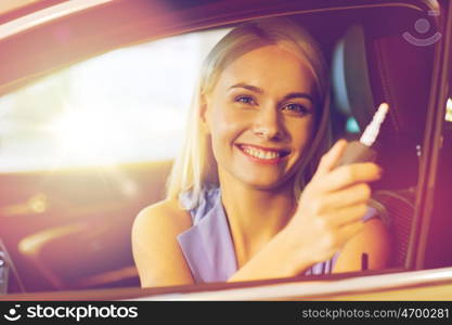 auto business, car sale, consumerism and people concept - happy woman taking car key from dealer in auto show or salon