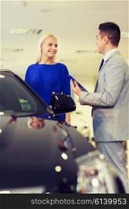 auto business, car sale, consumerism and people concept - happy woman with car dealer in auto show or salon