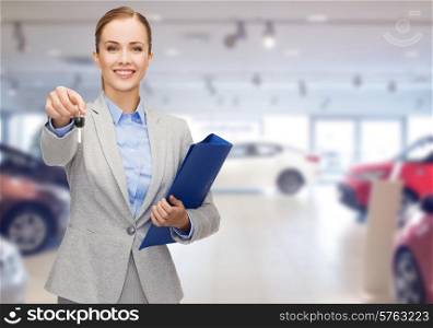 auto business, car sale, gesture and people concept - happy businesswoman or saleswoman with folder giving car key over auto show background