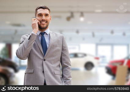 auto business, car sale, gesture and people concept - smiling businessman talking on smartphone over auto show background