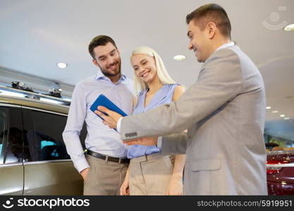 auto business, car sale, technology and people concept - happy couple with car dealer in auto show or salon