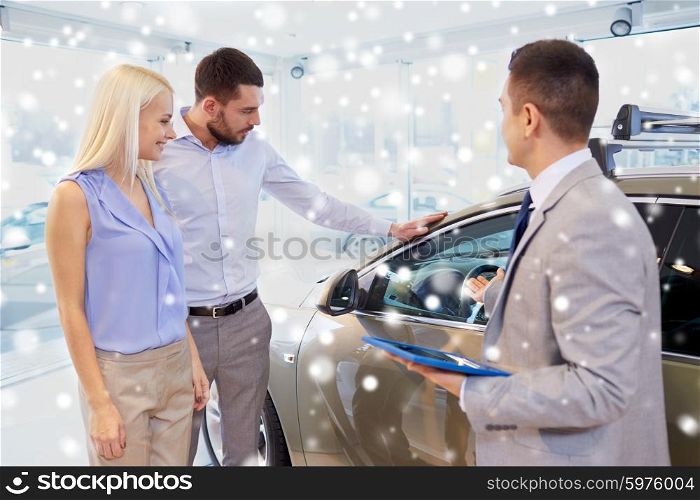 auto business, car sale, technology and people concept - happy couple with car dealer in auto show or salon over snow effect