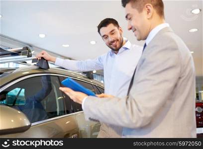 auto business, car sale, technology and people concept - happy man and car dealer with tablet pc computer in auto show or salon
