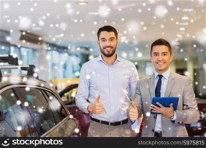 auto business, car sale, technology, gesture and people concept - happy man and car dealer with tablet pc computer showing thumbs up in auto show or salon over snow effect