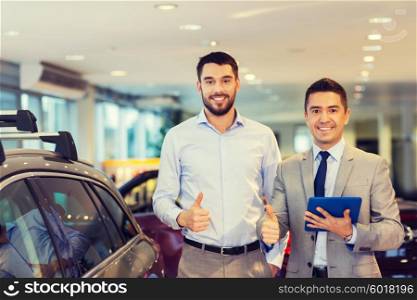 auto business, car sale, technology, gesture and people concept - happy man and car dealer with tablet pc computer showing thumbs up in auto show or salon