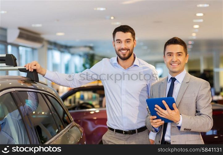 auto business, car sale, techology and people concept - happy man and car dealer with tablet pc computer in auto show or salon