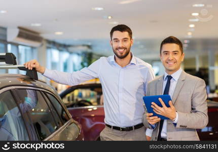 auto business, car sale, techology and people concept - happy man and car dealer with tablet pc computer in auto show or salon