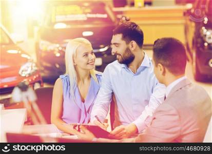 auto business, sale and people concept - happy couple with dealer buying car in auto show or salon
