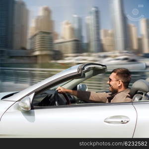 auto business, transport, leisure and people concept - happy man driving cabriolet car over dubai city port background