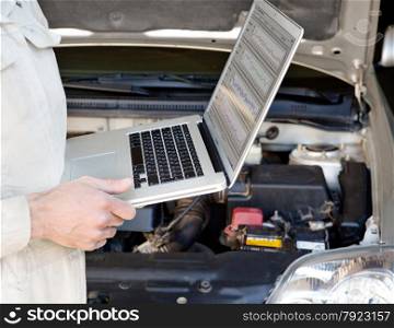 auto mechanic checks the car using a laptop