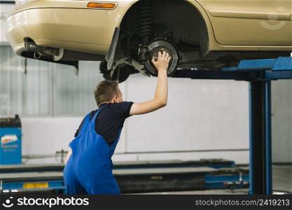 auto mechanic holding hob car