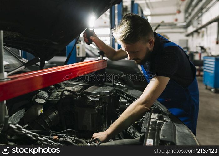 auto mechanic looking car s engine room