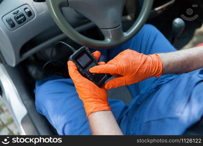 Auto mechanic using car diagnostic scanner tool