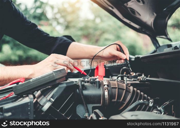 Auto mechanic working in garage Technician Hands of car mechanic working in auto repair Service and Maintenance check car battery.