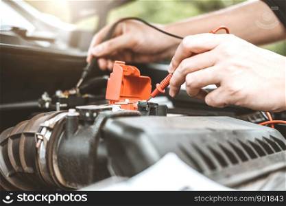 Auto mechanic working in garage Technician Hands of car mechanic working in auto repair Service and Maintenance car battery check.