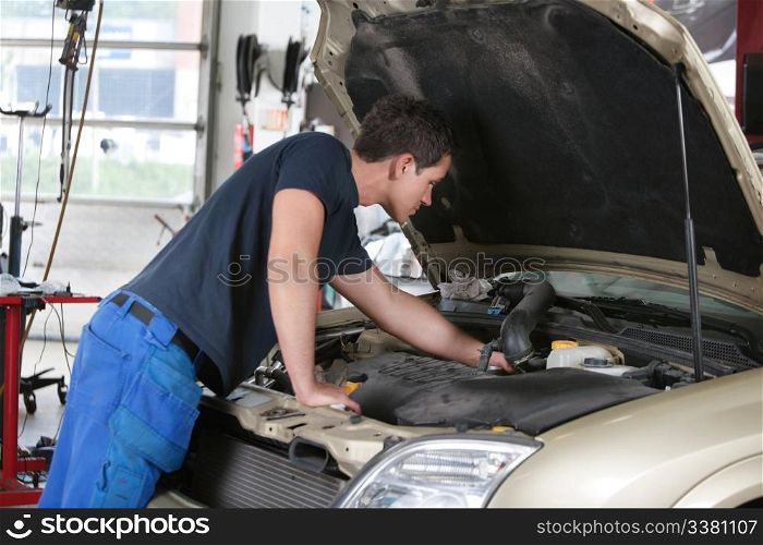 Auto mechanic working on a car in garage