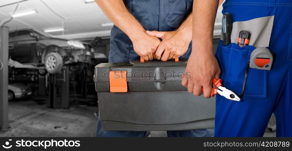 Auto mechanics closeup over workshop background