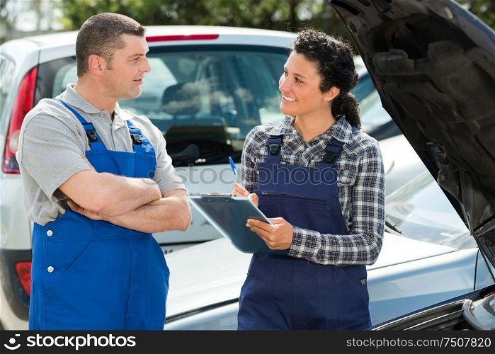 auto mechanics discussing something outdoors
