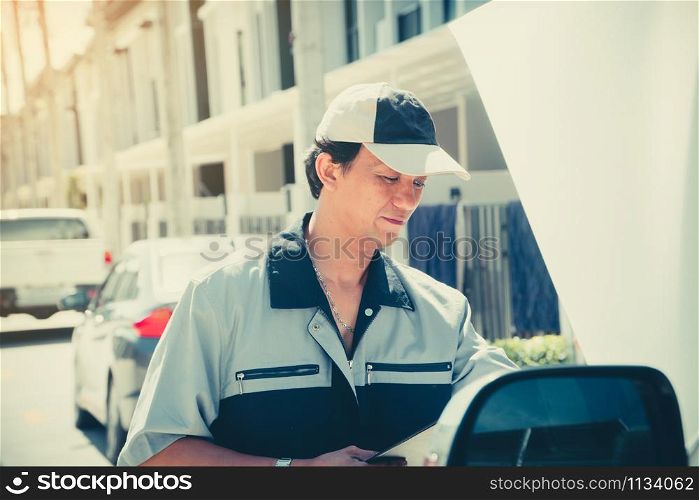 Auto repairman checks the engine before traveling on a long holiday.