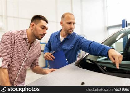 auto service, repair, maintenance and people concept - mechanic checking windshield wiper and man or owner at car shop