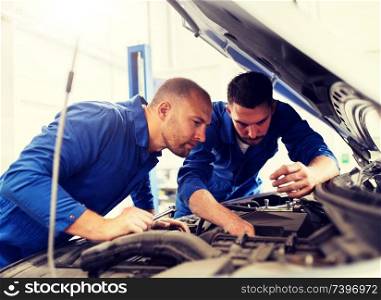 auto service, repair, maintenance and people concept - mechanic men with wrench repairing car engine at workshop. mechanic men with wrench repairing car at workshop