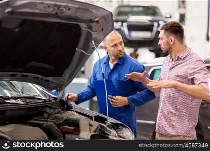 auto service, repair, maintenance and people concept - mechanic with clipboard and man or owner talking at car shop