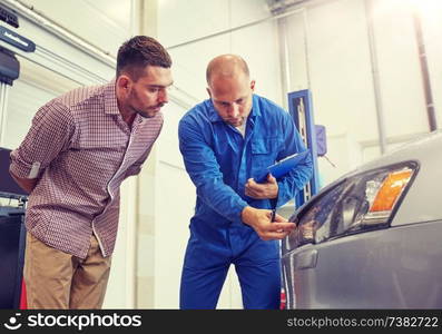 auto service, repair, maintenance and people concept - mechanic with clipboard and man or owner observing car at workshop. auto mechanic with clipboard and man at car shop