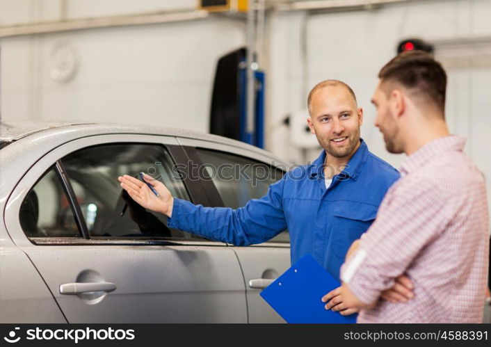 auto service, repair, maintenance and people concept - mechanic with clipboard showing side window to man or owner at car shop