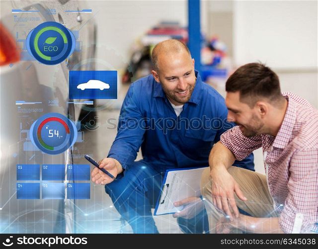 auto service, repair, maintenance and people concept - mechanic with clipboard showing tire to man or owner at car shop. auto mechanic with clipboard and man at car shop