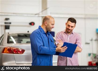 auto service, repair, maintenance and people concept - mechanic with clipboard talking to man or owner at car shop