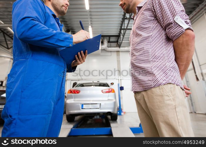 auto service, repair, maintenance and people concept - mechanic with clipboard talking to man or owner at car shop. auto mechanic with clipboard and man at car shop