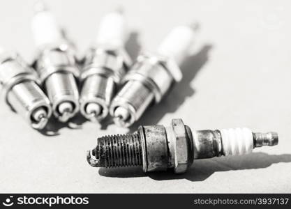 Auto service. Set of car spark plugs as spare part of auto transportation on gray.