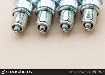 Auto service. Set of new car spark plugs as spare part of auto transportation on gray