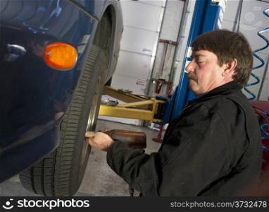 Auto technician works to repair problem with this car&rsquo;s brakes.