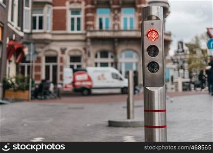 Automatic metallic bollard with red light with old city background