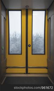 Automatic yellow doors from a modern train. Interior of a german passengers train with the corridor and sliding door