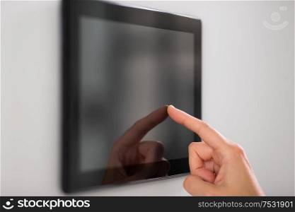 automation, internet of things and technology concept - hand using tablet pc computer at smart home. hand using tablet computer at smart home